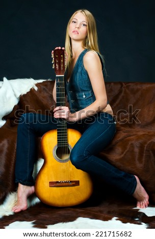 Portrait of the beautiful blonde girl with guitar