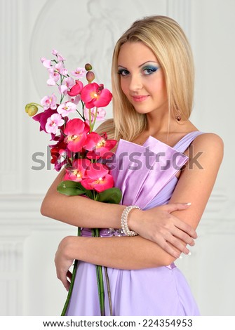Beautiful woman with orchid, in evening gown. Studio shoot.
