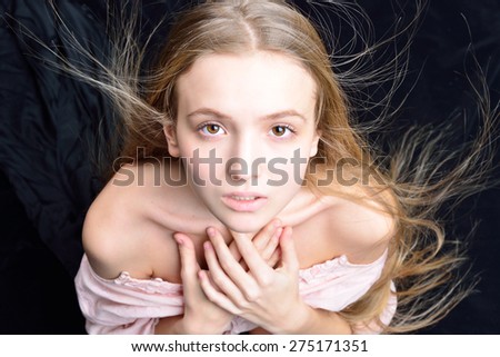 Portrait of the beautiful blonde woman with flying long hair. She is with naked shoulders  in studio .