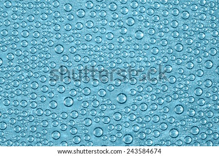 Turquoise Blue Water Droplets. Water condensation forms a random pattern of turquoise blue circular water droplets of varying sizes.