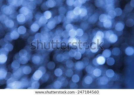 Shades of blue bokeh pattern background. Out of focus points of light form a background of multiple shades of blue and white.