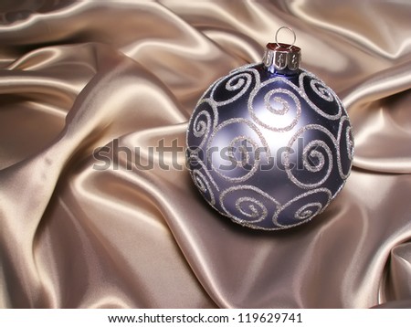 Christmas New Year balls on silk background. Blue Christmas decoration on milky silk.