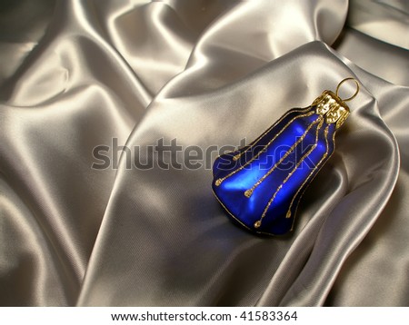 Dark blue with gold glass bluebell christmas decoration on a background light drapery