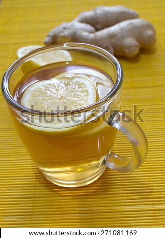 lemon tea with lemon pieces and ginger on the table