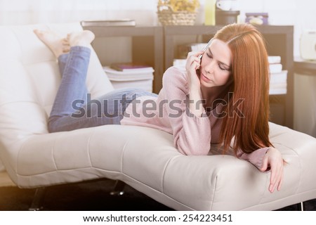 Woman talking to someone on the mobile phone in the room.