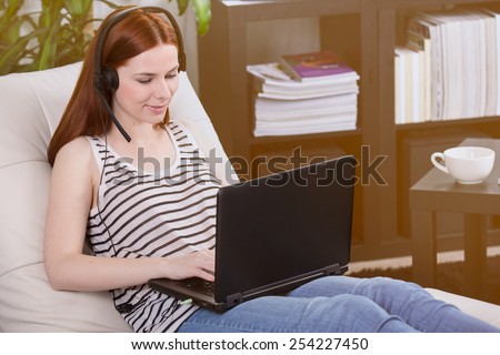 Woman talking to someone on the notebook in the room.