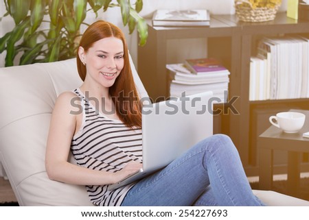 Woman read the notebook on the sofa in the room.