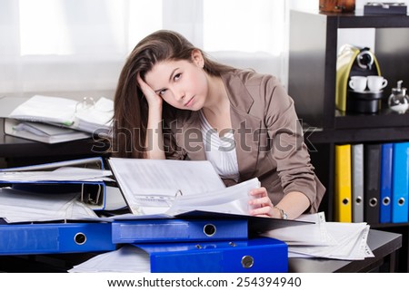 Business woman with so many paperwork in the office
