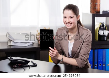 Elegant business woman show the tablet screen in the office.