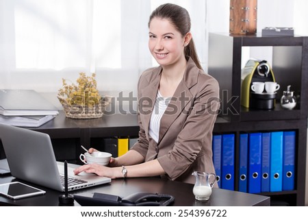 Elegant business woman drinking coffee in the office
