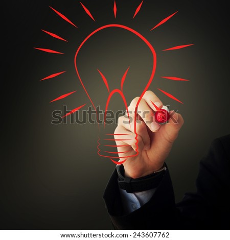 Business and advertisement concept. Close up of businessman drawing a light bulb