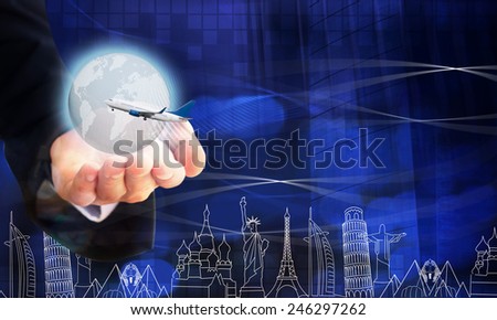 Young businessman holding airplane and digital earth, background famous landmarks