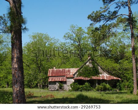 Old weathered, abandoned, historic home in south Georgia with a tin roof that is close to falling down.