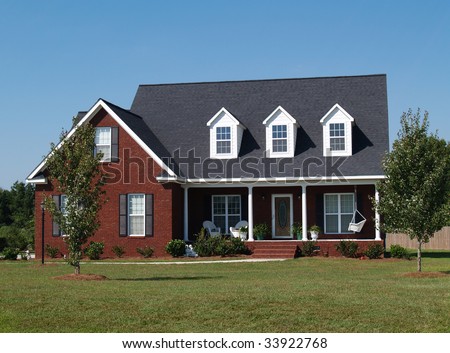 Two story brick residential home with porch swing.