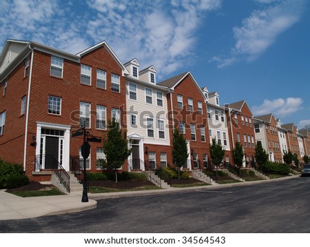 A row of brick condos or townhouses beside a street.