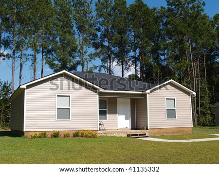 Small low income home with tan vinyl siding.