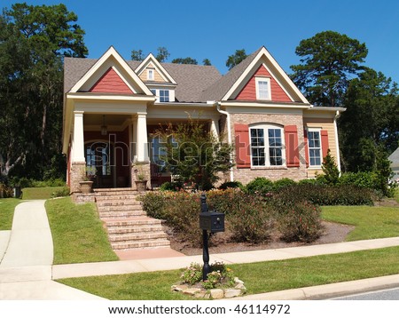 Beige brick home having peach and white trim with steps leading up to squares columns on the porch.