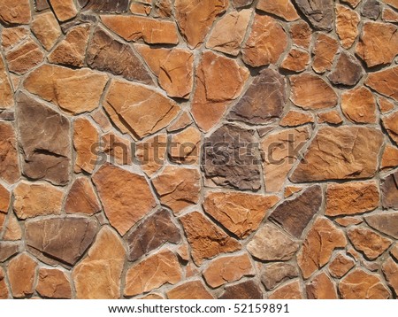 Multi-colored and multi-sized, orange and brown rock wall grunge texture background.
