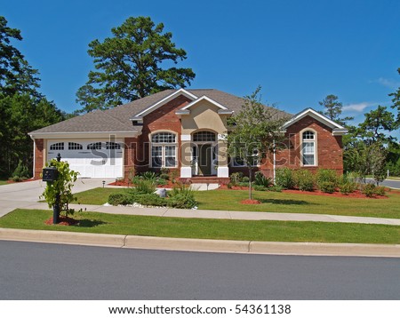 Single story brick residential home with the garage in the front.