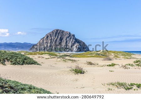 Sand dunes & majestic Morro Rock over looking the Pacific Ocean, next to Morro Strand state beach, on the California Central Coast, near Cambria, CA.