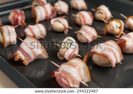 Uncooked mushrooms and cheese rolled in bacon