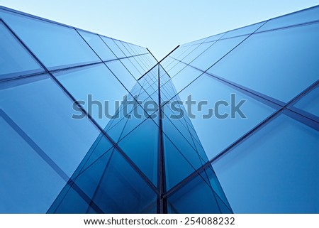 Abstract image of the facade of a modern high rise building covered in reflective plate glass