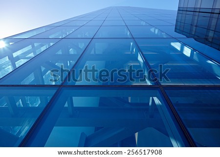Abstract closeup of the glass-clad facade of a modern building covered in reflective plate glass