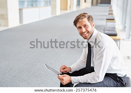 Portrait of a corporate executive smiling while using a digital tablet