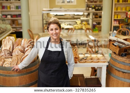 A young deli employee standing in front of the pastry display