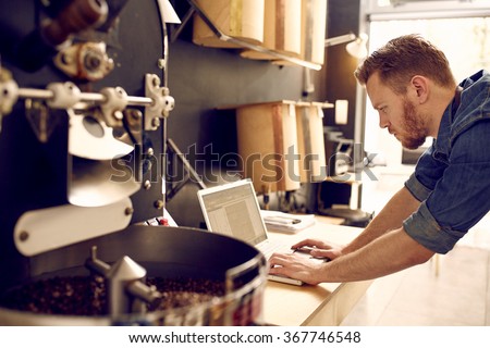 Business owner of a coffee roastery checking his laptop