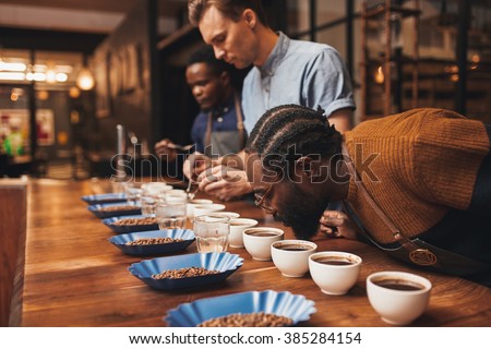 Baristas training with variety of coffee beans in modern roaster