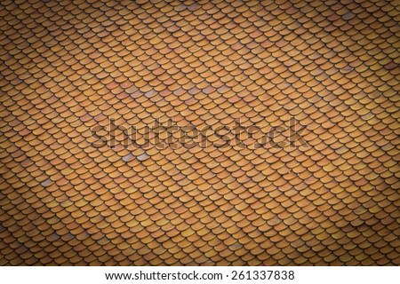 Orange-yellow roof tiles in temple of thailand for texture background