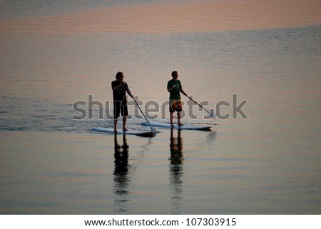 paddle boarders at dusk