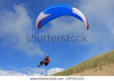 paraglider above sand dunes