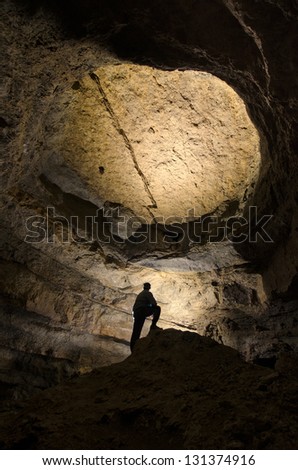 man silhouette in a huge dark cave