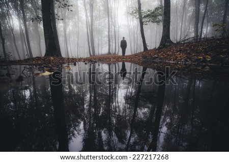 man reflection in lake in fantasy forest in autumn