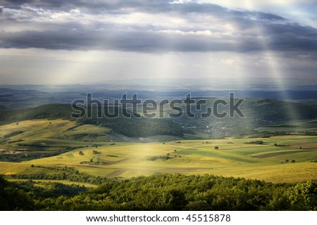 sun rays over green hills
