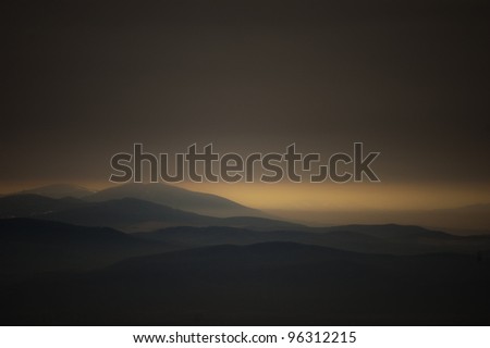 dark landscape with mountains at sunset