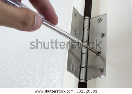 Door repairing. Close-up of repairing door hinge.