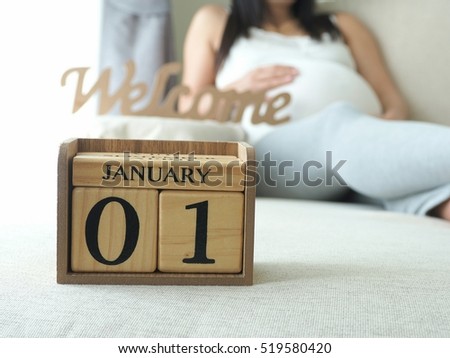 Baby\'s due date on a calendar with pregnant woman background. Maternity concept. Expecting an upcoming baby. Due date countdown.