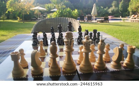 A chess board set up for a game in the garden