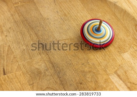 Spinning top.\
A wooden spinning-top in action on a wooden handmade table.