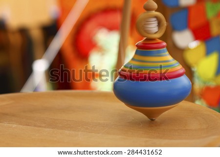 Spinning top. A wooden spinning-top in action on a wooden handmade table.