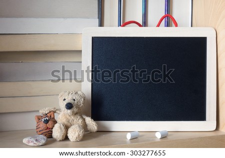 Clean wooden chalkboard on a bookshelf. Space for your text.