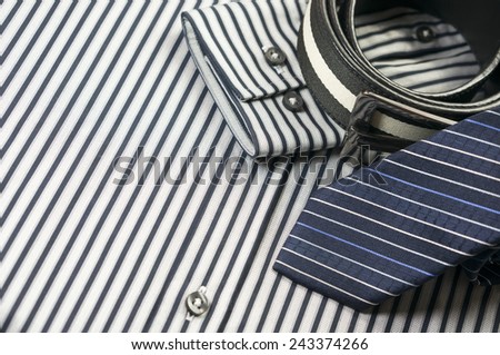Tie and belt on striped shirt background
