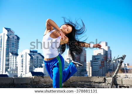 fitness dancing girl on the roof blue sky