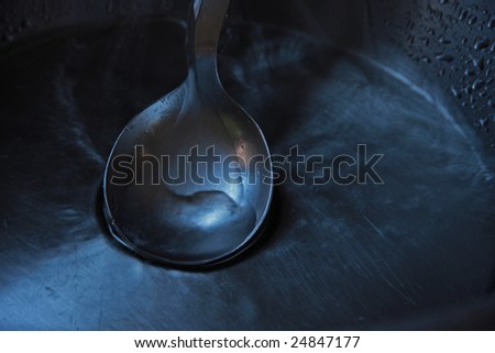 closeup shot of a serving spoon on a stainless steel sink
