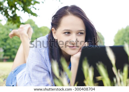 Woman with notebook on a grass in a nature