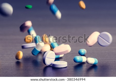 Pharmacy background on a dark table. Levitation pills. Tablets on a dark background which falling down. Pills. Medicine and healthy. Close up of capsules. Differend kind of pills