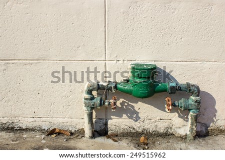 Old Green Color Water Meter with Cement block wall